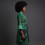 Woman wearing a green patterned dress against a gray background