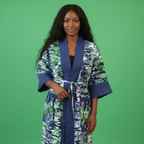 Woman wearing a patterned robe against a green background