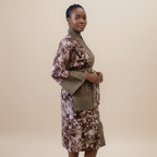 Woman wearing a patterned dress with a plain background