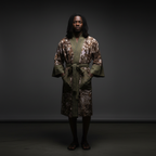 Person wearing a patterned robe against a dark background