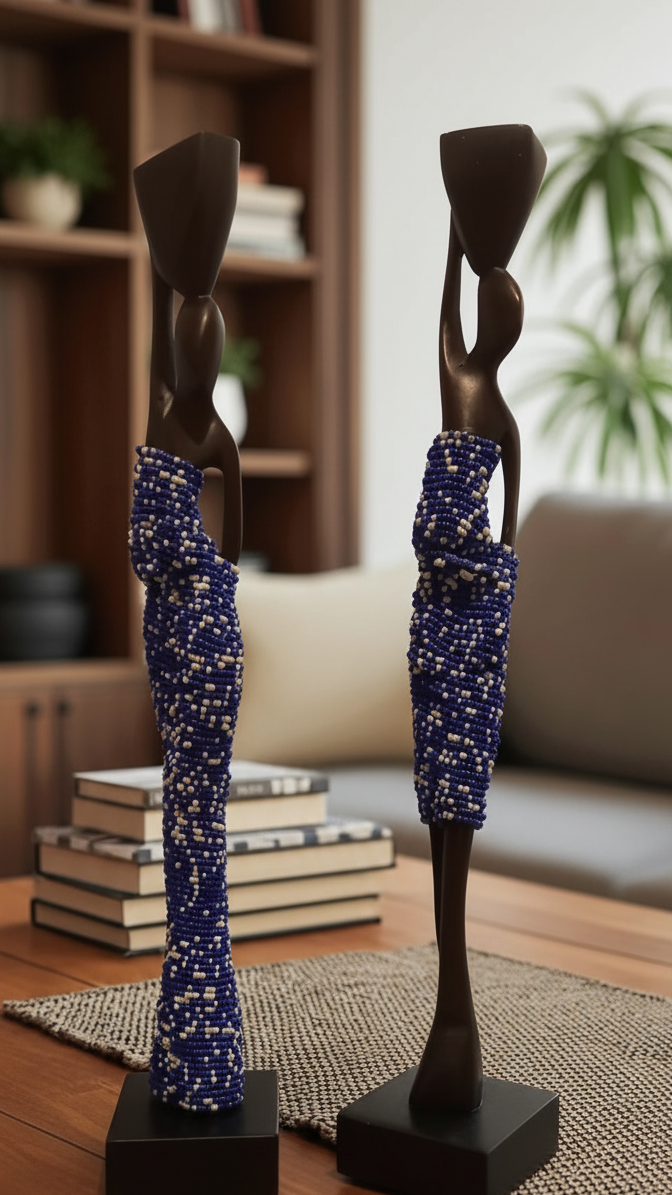 Two decorative statues on a wooden surface with a blurred indoor background