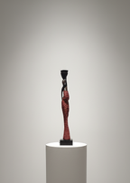 Stylized sculpture of a figure on a white pedestal against a plain background