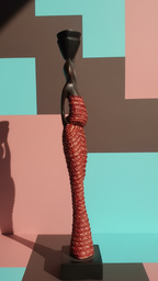 Statue with textured red dress and black base on a geometric patterned background