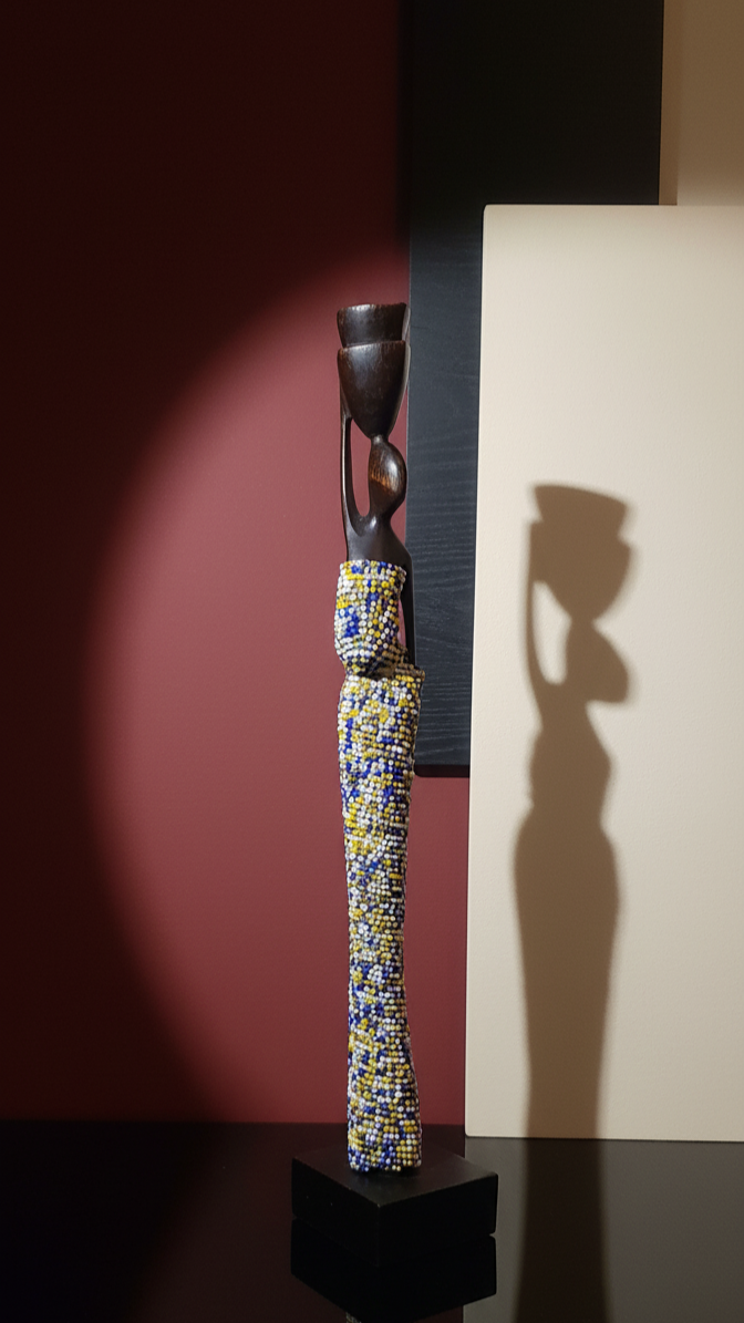 Decorative vase with colorful patterns on a black base against a dark background