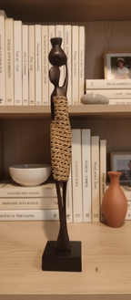 Decorative figure on a shelf with books and a vase