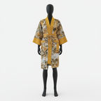 Mannequin wearing a patterned robe with yellow accents on a white background