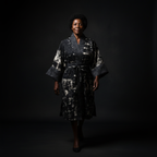 Woman wearing a dark patterned dress against a black background